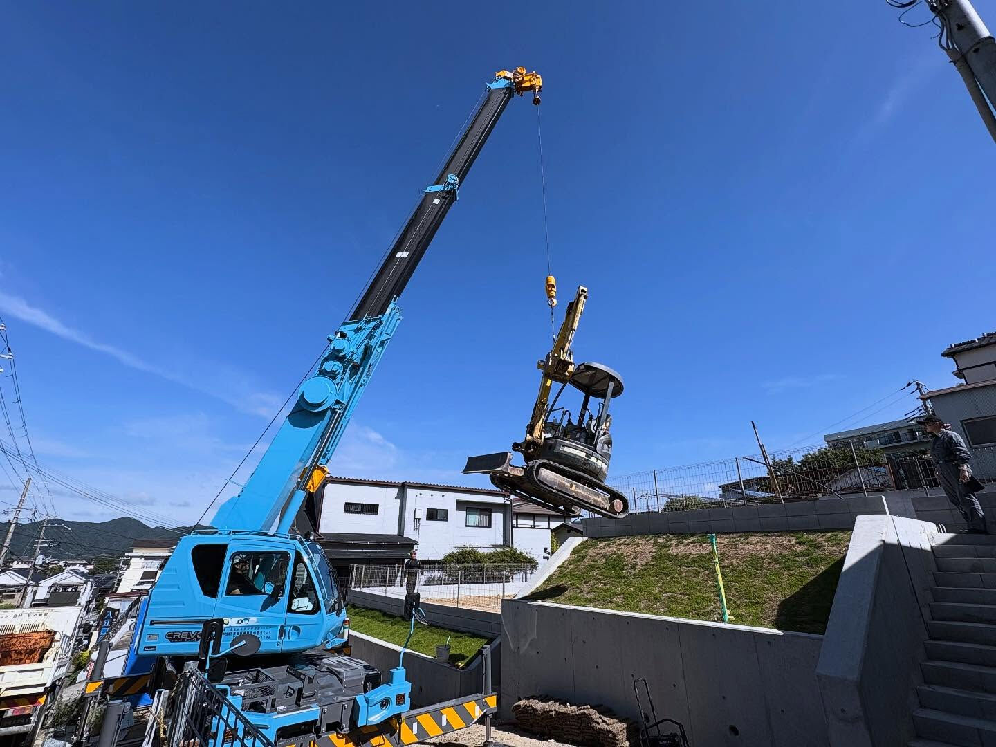 神戸市北区の新しい建設現場において、高台の擁壁に位置する作業